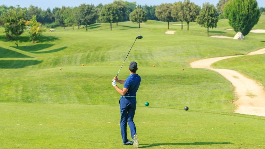 Un golfista effettua un tee shot sul campo di Peschiera del Garda